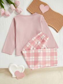 Conjunto de blusa e calça xadrez com estampa de corações, gola redonda e mangas compridas.