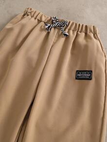 SHEIN 2 件/套时尚白色连帽衫搭配橄榄绿色裤子，适合青少年男孩的时尚服装，连帽衫采用绿色定位印花，面料柔软舒适，适合春秋季穿着，适合上学、郊游等。 - 卡其色 - 查看 5