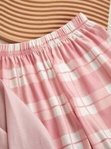 Conjunto de blusa e calça xadrez com estampa de corações, gola redonda e mangas compridas.
