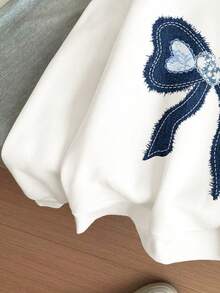 Sudadera de cuello redondo de manga larga, suelta y cómoda, de tela gruesa y suave, con estampado de lazo azul vaquero en un estilo minimalista casual para niñas preadolescentes, adecuada para el uso diario en otoño/invierno, temporada acogedora, atuendos de otoño e invierno, comodidad fácil, capas de otoño e invierno para niñas, ropa gráfica con lazo para niños, ropa de otoño e invierno, ropa nueva para el Año Nuevo, elegante otoño, moda de invierno, nuevo estilo