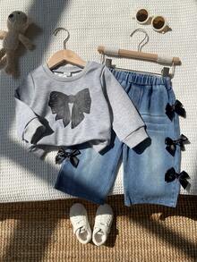 SHEIN Playful Pals 两件套女婴时尚休闲街头风套装，包括一件灰色圆领长袖卫衣（饰有黑色蝴蝶结印花）和一条蓝色阔腿牛仔裤（饰有黑色丝带蝴蝶结），适合上学和日常穿着，春秋季皆宜。