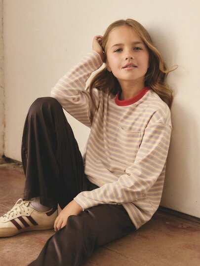 春秋季女童长袖T恤，专为青少年设计：柔软的多色条纹面料（米白色底色，饰以蓝色和红色细条纹），宽松版型，经典圆领搭配醒目的红色罗纹饰边，以及实用的胸袋。轻盈舒适，适合日常穿着，例如上学，既可叠穿也可单穿。