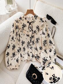 SHEIN 这款少女长袖衬衫采用荷叶边领、泡泡袖设计，杏色底布上印有黑色花卉图案，并带有纹理质感。纽扣式设计使其适合日常穿着、休闲外出以及秋季度假。