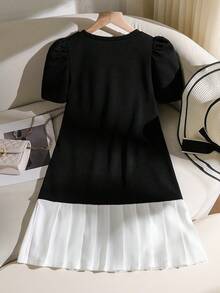 一件春夏温柔优雅连衣裙，短袖、圆领、泡泡袖拼接中长连衣裙，专为可爱时尚的女孩设计。非常适合日常通勤和下午茶场合。这款撞色优雅连衣裙以黑色为底，饰以珍珠，并配有立体白色蝴蝶结装饰和褶裥下摆。 - 黑色 - 查看 2