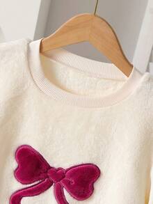 1套圣诞快乐女孩睡衣 - 酒红色毛绒蝴蝶结和奶油色刺绣长袖上衣，蝴蝶结装饰毛绒裤子。柔软针织面料，穿着舒适，可机洗。3件套单独出售