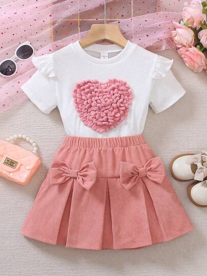 SHEIN Conjunto de camiseta de manga corta con cuello redondo y volantes con decoración de corazón, y falda mini plisada con decoración de lazo para niña