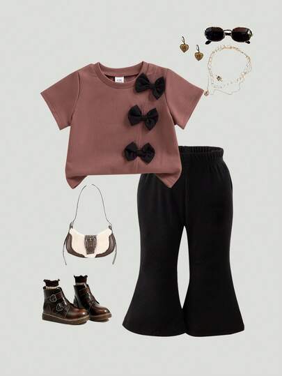 SHEIN 2 piezas Conjunto de moda de verano para niña bebé, con camiseta de manga corta de cuello redondo marrón simple y linda con decoración de lazo negro en el frente, combinada con pantalones acampanados negros, adecuado para uso diario y sesiones de fotos