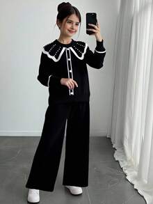 Sparklyn 少女黑色毛衣套装 - 甜美风格，饰有厚重荷叶边领、宽翻领和3D珍珠点缀。宽松百搭的优雅针织两件套（长袖开衫+长裤），设计温柔时尚。适合日常穿着、节日庆典、外出、旅行、度假、居家穿着以及返校造型，细节丰富，百搭实用。 - 黑色 - 查看 1