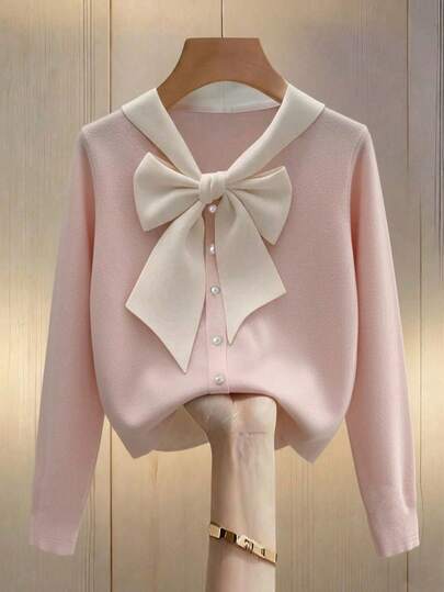 Franclia 粉白撞色设计，秋冬新款，青春气息的浅粉色蝴蝶结装饰门襟，珍珠纽扣点缀，女士针织长袖T恤，适合冬季圣诞节和新年穿着。