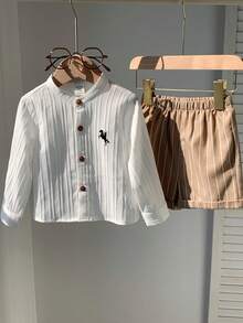 男婴两件套服装 - 白色长袖衬衫搭配卡其色条纹短裤，袖长可调节。舒适百搭，休闲时尚，适合春夏室内、室外、日常穿着、运动、派对、拍照、节日、街头风、新年等场合。男婴纽扣衬衫和短裤棕色男婴套装 - 卡其色 - 查看 9