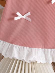 小女孩粉色针织上衣，饰有5个蝴蝶结，搭配宽松的粉色针织裤，时尚可爱，适合日常通勤。