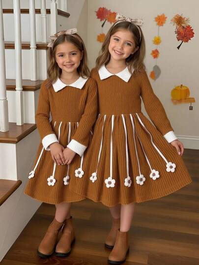 SHEIN Elladie kids 这款可爱的长袖连衣裙采用经典的彼得潘领设计，撞色袖口，以及喇叭裙摆上俏皮的花朵装饰。非常适合家庭聚会、休闲派对或秋冬季日常外出——既舒适又时尚，是小女孩的理想之选。