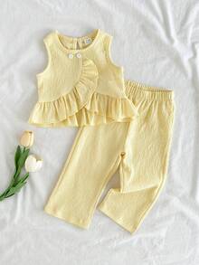 SHEIN Vintaside Kids 这款女童春夏两件套，亮黄色无袖上衣搭配直筒裤，清新甜美又时尚。面料厚度适中，饰有不对称荷叶边和白色纽扣，尽显优雅气质。适合上学通勤、度假旅行、舞蹈练习、居家休闲以及参加派对等各种场合。 - 黃色 - 查看 3