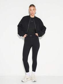 KIZN Camiseta de mujer de cuello redondo, manga corta y ajustada con acabado brillante y detalle de logo pequeño - Negro - Ver 5