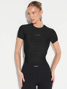 KIZN Camiseta de mujer de cuello redondo, manga corta y ajustada con acabado brillante y detalle de logo pequeño - Negro - Ver 6