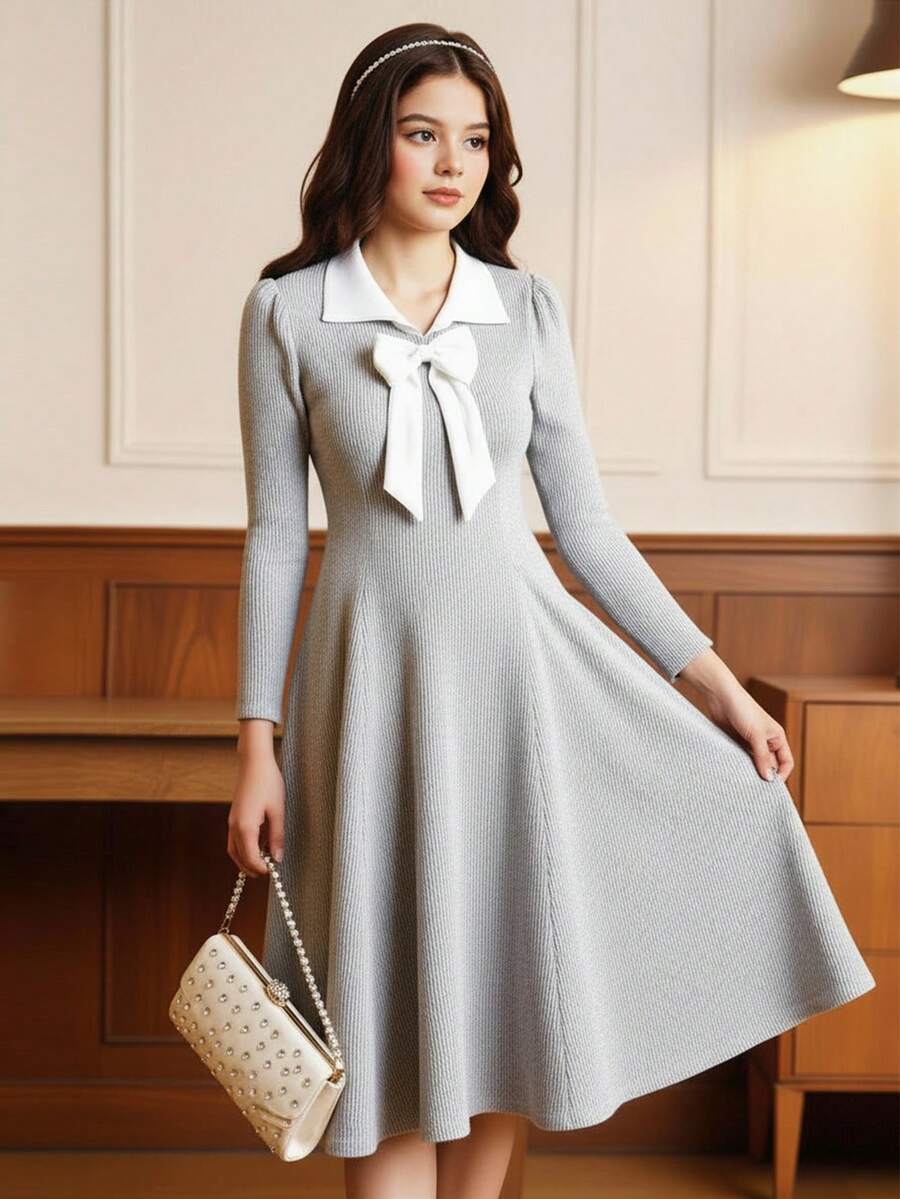 Váy dài tay thu đông cho bé gái tuổi teen được làm từ vải dệt kim gân mềm mại, thân thiện với làn da. Váy có thiết kế cổ Peter Pan màu trắng cổ điển, kết hợp với nơ lớn trang trí cầu kỳ ở ngực. - Xám - Xem 1