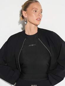 KIZN Camiseta de mujer de cuello redondo, manga corta y ajustada con acabado brillante y detalle de logo pequeño - Negro - Ver 3