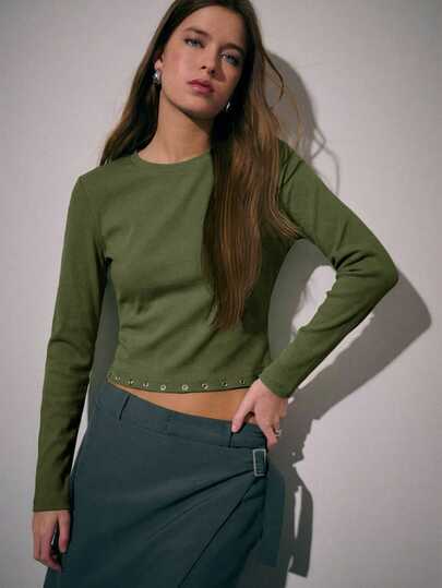 Nöista 女士修身长袖露脐上衣，圆领设计，下摆饰有铆钉。这款时尚弹力上衣专为日常穿着、休闲装扮和外出造型而设计。非常适合春季穿搭、度假造型，或搭配裙装和修身长裤，打造优雅摩登的造型。