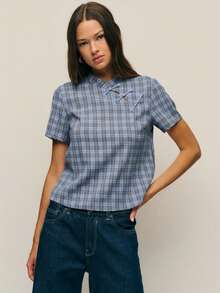 Nöista 这款少女风上衣采用立领设计，融入了中国风元素。三颗纽扣更添东方韵味。短袖直筒版型，简洁利落的剪裁提升了穿着舒适度，营造出休闲随性的氛围。格纹图案打造出复古学院风，同时又不失日常休闲感。无论是休闲外出、与朋友聚会叠穿，还是参加文化活动，它都能轻松融入复古或甜美风格。