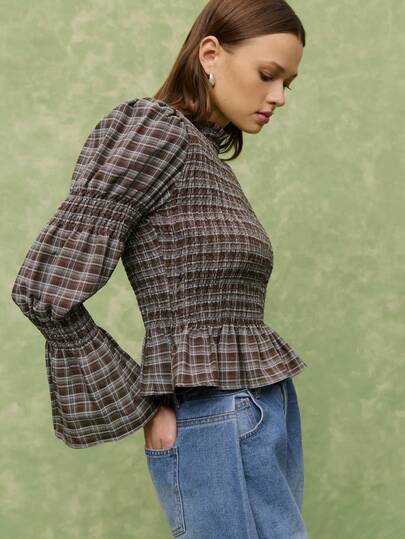 Nöista 褶皱格纹泡泡袖衬衫，柔软的荷叶边下摆。这款充满女性魅力的纹理上衣，是夏季穿搭的完美之选——无论是春假装扮、优雅休闲造型，还是节日度假、情人节等场合的季节性穿搭，都能轻松驾驭。