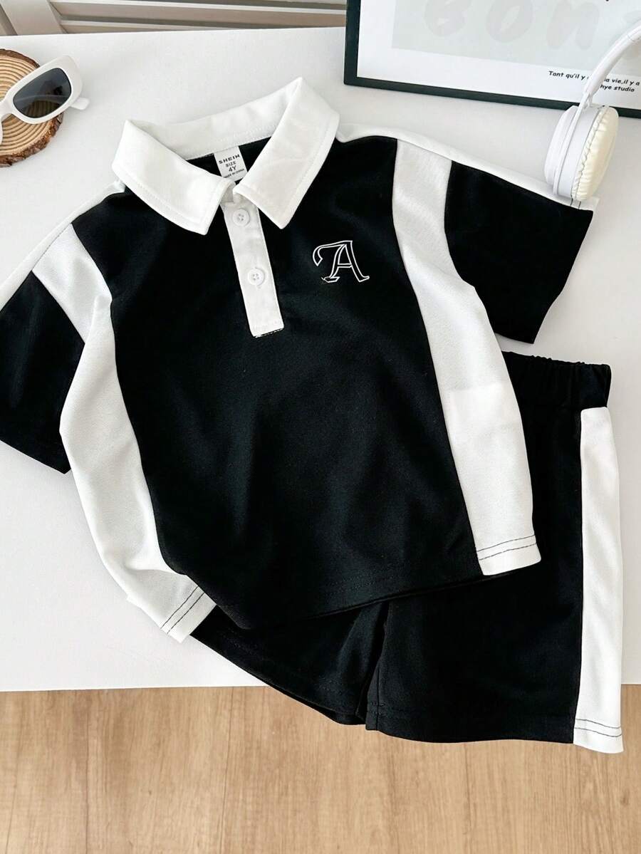 SHEIN Explorewe 2件套男童活力运动黑白拼接短袖polo衫和拼接彩色运动短裤,主体为黑色,领口、门襟和侧边拼接白色面料,胸前饰有白色字母A图案,翻领设计配两颗白色纽扣,简约运动风格,适合所有季节,适合日常玩耍、郊游、慢跑等。 - 黑色 - 查看 1