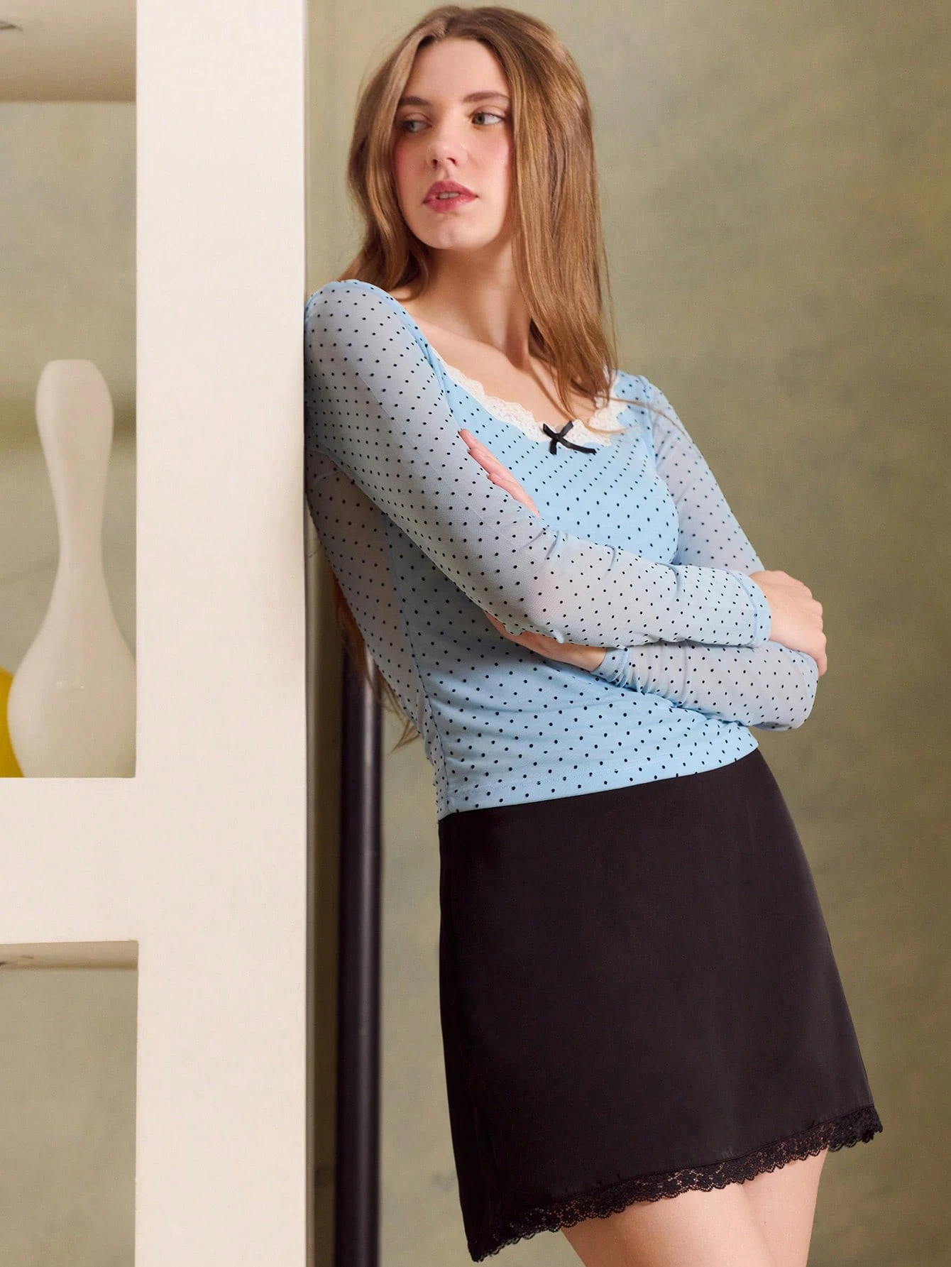 Top à manches longues avec pois bleu clair en maille, col avec dentelle blanche et nœud noir. Style vintage mignon