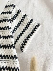 SHEIN Vintaside Kids 这款男宝宝夏季时尚套装，采用黑米条纹V领短袖上衣搭配同款无腰短裤，尽显绅士风范。套装采用黑米条纹设计，简约而不失独特，为您的宝宝增添别致的时尚魅力。