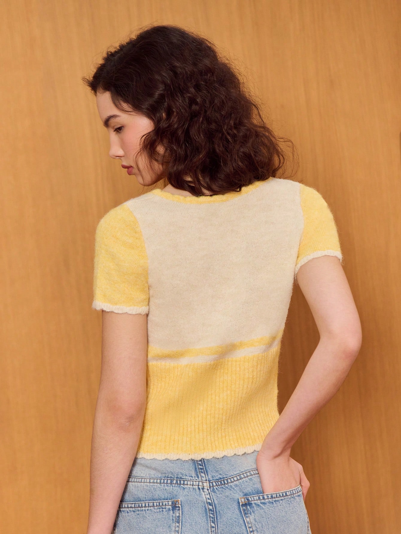 Blusa de punto suave de manga corta color amarillo mantequilla con detalles en contraste crema y cierre de botones
