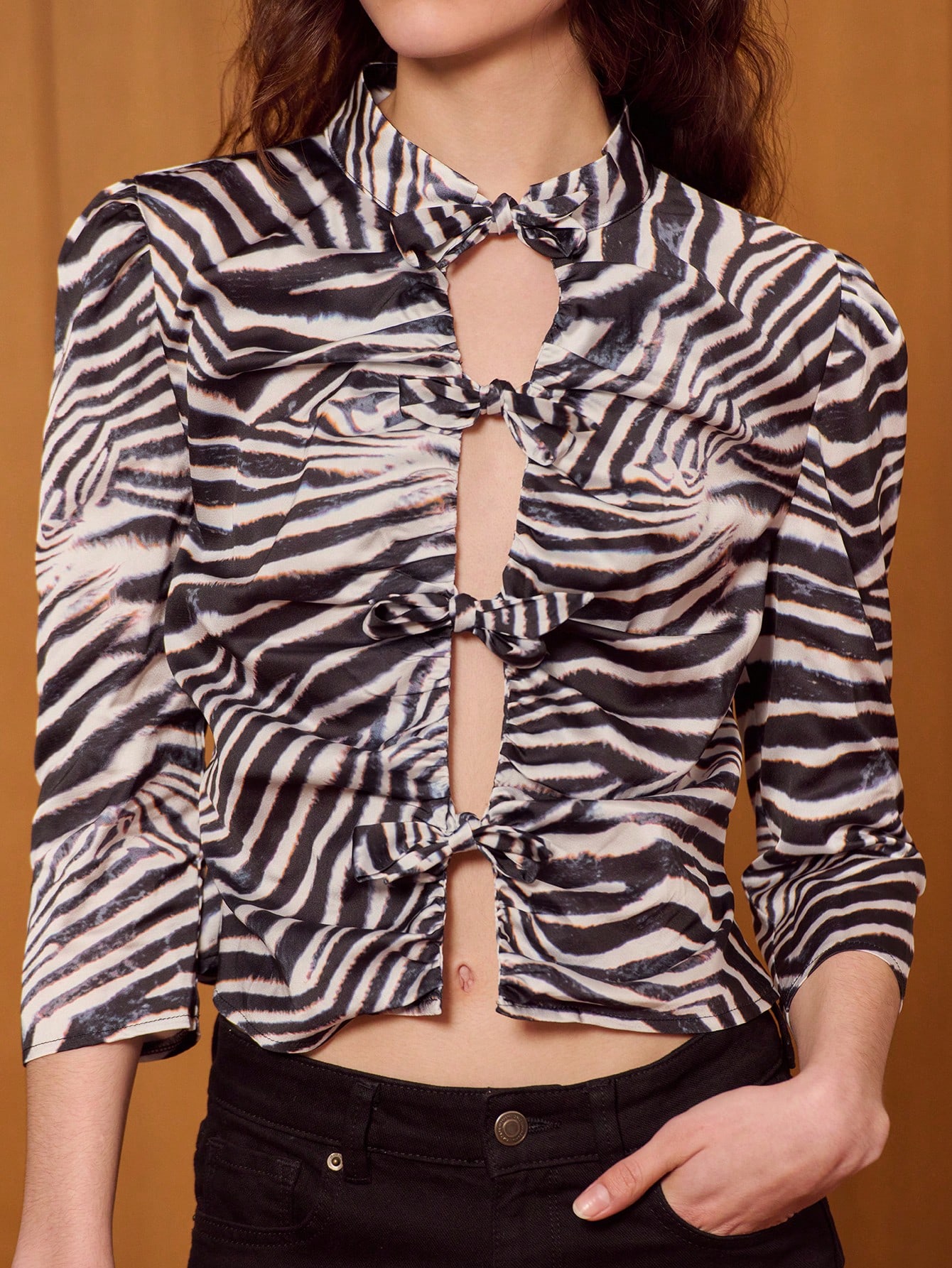 Dopasowana satynowa bluzka w zebrę z zapięciami na kokardę i marszczeniami z przodu, która zapewni wyrazisty wygląd. Wyjściowy top w zwierzęcy wzór. Styl francuski. Paryski styl.