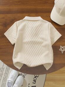 SHEIN Streecool Kids 一件男童米色 Polo 衫，领口和袖口饰有黑色滚边，增添细节感；菱形纹理图案提升质感；左胸饰有创意“皮革贴片”设计；适合商务休闲、通勤、半正式社交活动和学校穿着。 - 米色 - 查看 2