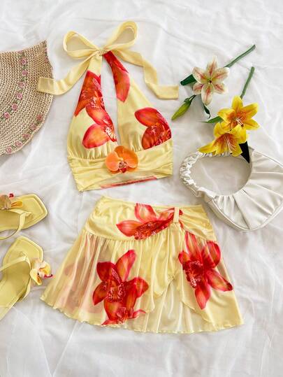 Soleia Damset med djup V-ringning, blommig dekoration, linne och volang, asymmetrisk fåll, moderiktigt set för resort och strand.