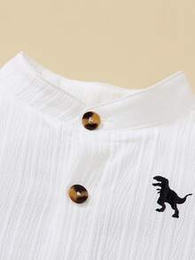 Souflis Souflis 两件套儿童男童校服，包括一件白色短袖衬衫（棕色纽扣，黑色恐龙印花）和一条蓝色束口短裤。舒适休闲，适合日常穿着。 - 白色 - 查看 5