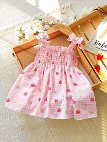 SHEIN Vintaside Kids 这款女童夏季粉色格子吊带连衣裙，以柔和的粉色格子为底色，点缀着新鲜草莓图案，可爱俏皮，散发着甜美乡村公主风情。连衣裙采用梭织面料，A字版型，肩带上的蝴蝶结装饰灵动可爱。适合草莓园拍照、校园活动、居家休闲、度假旅行以及参加派对等各种场合。 - 粉色 - 查看 4