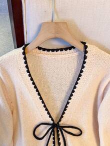Franclia Áo khoác cardigan dáng rộng đơn giản mới, thắt nơ phía trước, cổ chữ V với viền gợn sóng tương phản, tinh tế và thu hút, chất liệu dệt kim mật độ cao mềm mại và ấm áp, phù hợp cho công sở hoặc mặc thường ngày, phối đồ nhẹ nhàng và thanh lịch, màu đào nhạt với độ bão hòa thấp tạo cảm giác thư giãn, áo len nữ năng động và dễ thương. - Nhiều màu - Xem 5