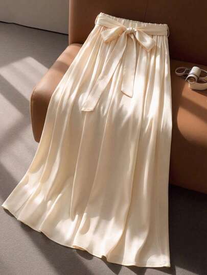 女童米色蝴蝶结半身裙，柔美A字廓形，可爱蝴蝶结装饰，轻盈飘逸，融合少女元素，适合春夏及各种甜美场合。