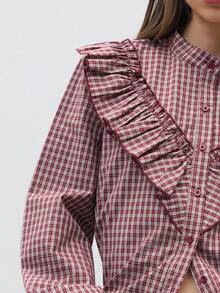 Nöista 这款格纹长袖衬衫饰有荷叶边和纽扣前襟，廓形宽松又不失女性柔美。它是一款百搭的休闲衬衫，非常适合作为春季上衣、夏季衬衫或度假装。无论是日常穿着、外出造型还是情人节装扮，它都能轻松搭配牛仔裤或裙子，完美融合休闲优雅与一丝Y2K复古风情。 - 紅色 - 查看 6