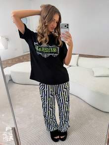 Beetlejuice X SHEIN Conjunto de pijama con top de manga corta con gráfico de letras y pantalones con estampado de rayas para mujer - Negro - Ver 1