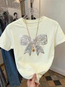 Resyla Áo thun nữ tay ngắn cổ tròn dáng regular fit, thanh lịch với nơ thắt và đính sequin. - Màu be - Xem 3