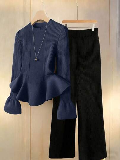 Franclia 两件套女士优雅针织衫套装，适合秋季通勤穿着。这款藏蓝色针织衫采用圆领、长袖、收腰设计，并饰有荷叶边下摆，搭配简约的黑色弹力腰针织裤。