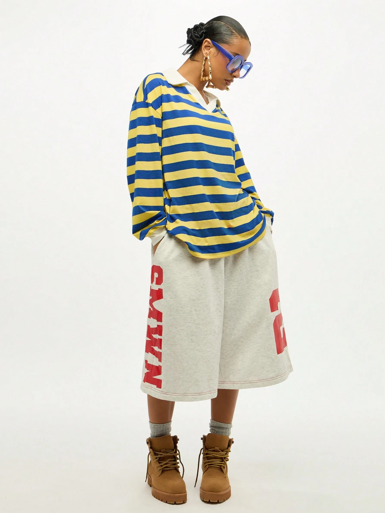Blusa oversized listrada com decote em V e detalhe de amarração.