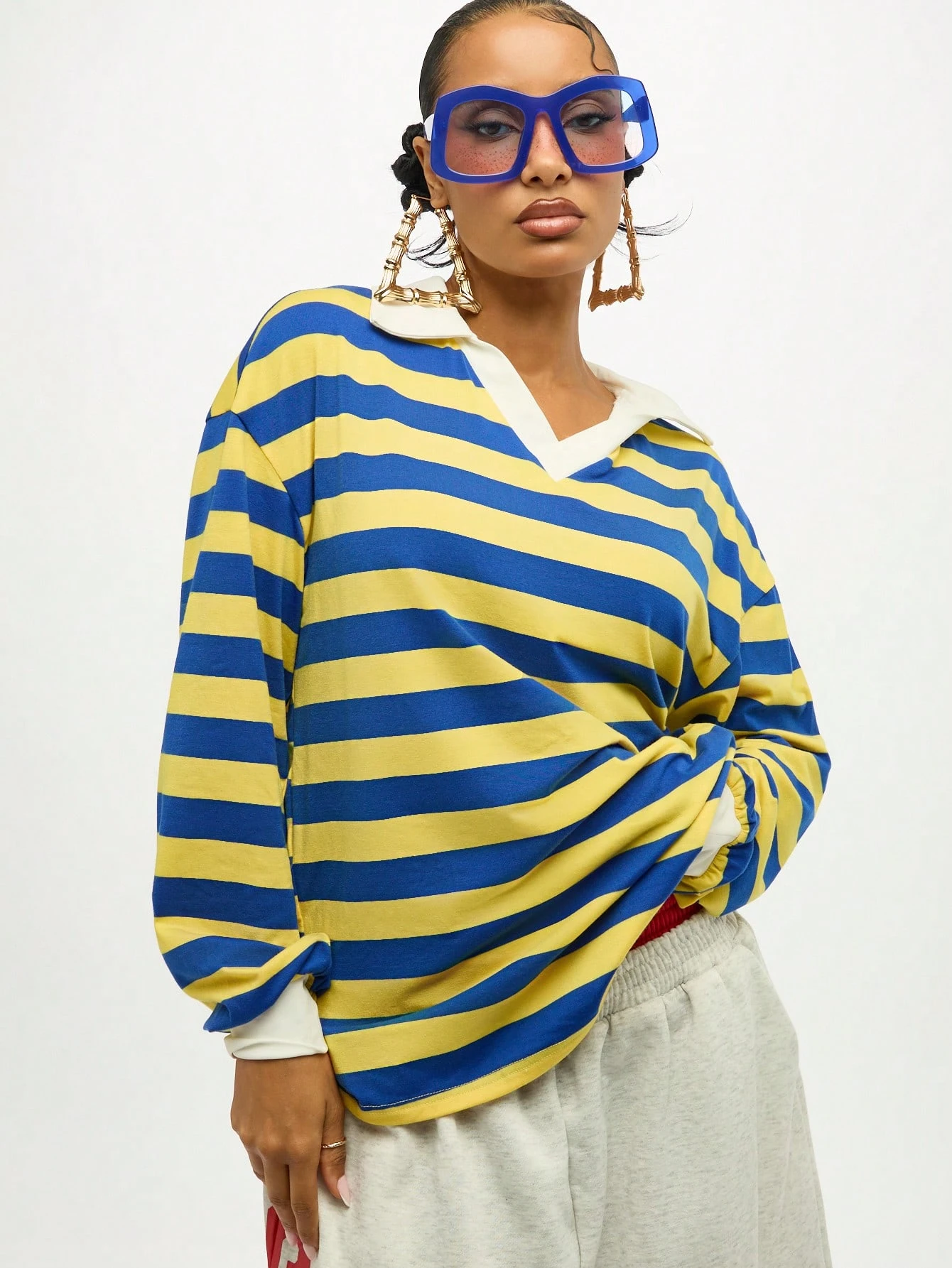 Blusa oversized listrada com decote em V e detalhe de amarração.