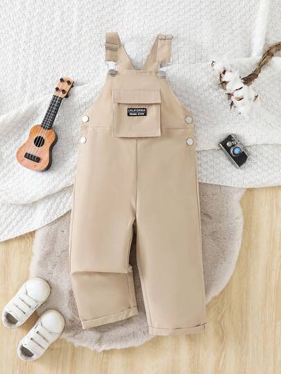 Young Boys' Khaki Cargo Bib Overall Pants. Designed In Classic Khaki Cargo Style, The Bib Overall Pants Are Simple And Neat, Showcasing The Active Personalized Of Young Boys. Suitable For Daily Activities And Outdoor Play. The Style Accordion Large Pockets Design Increases Storage Space, With A Strong Sense Of Style And High Practicality, Presenting A Perfect Combination Of Trendiness And Childlike Charm. Easy To Put On And Take Off, Suitable For Both Casual Daily Wear And As A Fashionable Highlight In Outfits.