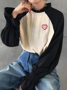 FRIFUL Camiseta holgada de manga larga con cuello de tortuga medio, mangas raglán de color contrastante, volantes y etiqueta de punto con corazón, estilo casual de calle para mujer - Negro - Ver 1