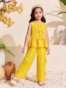 Bộ đồ thường ngày cho bé gái gồm áo không tay cổ tròn có nơ và viền bèo, kết hợp với quần ống đứng cạp chun cùng màu có điểm nhấn nơ. Chất liệu mềm mại, thoải mái, thích hợp cho các hoạt động mùa xuân/hè, kỳ nghỉ, mua sắm và chụp ảnh. Kiểu dáng thanh lịch và đơn giản. - Màu be - Xem 7