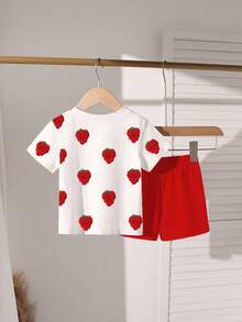 一套甜美可爱的印花圆领短袖T恤和短裤套装，专为女婴设计，适合派对和聚会。T恤采用甜美的草莓印花设计，搭配红色短裤。轻盈舒适，是春夏休闲穿着、户外活动、街头摄影、校园、节日庆典和送礼的理想之选。