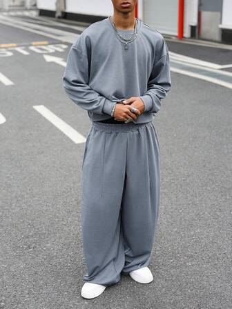 Manfinity Roghcode סט מכנסיים ארוכים עם קפלים בגזרה רפויה בצבע אחיד לגברים, גזרה נינוחה, כתף נפתחת ומכנסיים ארוכים עם קפלים במותן אלסטי