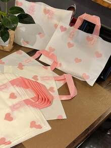 100/20个装心形图案加厚塑料礼品袋，可重复使用，大容量购物袋，生日惊喜礼品包装。心形磨砂手提袋，精致磨砂工艺，优雅便携设计，轻松营造生日、返校派对、婚礼、新娘送礼会、婴儿送礼会、万圣节、圣诞节、感恩节等场合的隆重送礼氛围。 - 彩色 - 查看 1