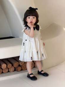 SHEIN Vestido negro de patchwork para niña este verano con cuello de bebé y pequeñas mangas voladoras que presenta un estilo de país elegante, dulce y retro. La tela tejida es de grosor moderado y cómoda. Los estampados florales del vestido son exquisitos y delicados. El corte holgado en línea A y el bajo con volantes lo hacen adecuado para la escuela, tomar fotos y registrarse, vacaciones, relajarse en casa y asistir a fiestas. - Blanco y Negro - Ver 8