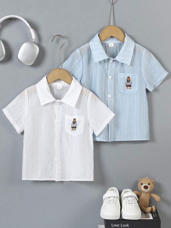 两件装男童小熊刺绣衬衫，白色和浅蓝色可选，翻领带胸袋，宽松版型方便活动，简约又不失趣味的设计，适合周末郊游、家庭聚会和返校穿着。