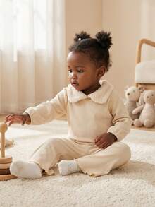 SHEIN Conjunto de duas peças para bebê menina, fofo, doce e moderno, em tons de creme, bege e damasco, com textura canelada, gola Peter Pan em sherpa e detalhes em alface. Blusa de manga comprida e calça boca de sino com cintura elástica. Roupa macia para uso diário, em casa, no outono e inverno. - Bege - Ver 1